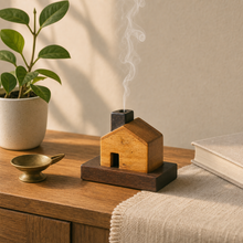 Kutir on a wooden sideboard beside a plant and a brass diya